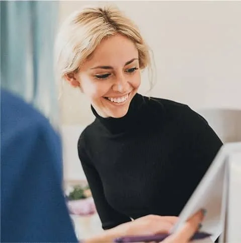 Smiling blonde woman during a consultation at a desk at Cool Clinic, CoolSculpting fat freezing Dublin